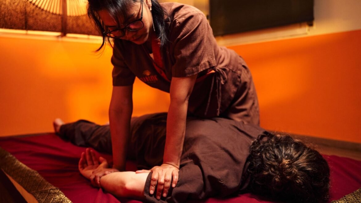 Masajista de Chiang Mai Tha Massages haciendo masaje tradicional tailandés en Barcelona sobre esterilla